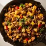 Crispy corned beef hash recipe in a rustic cast iron skillet.