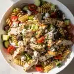 Creamy Greek chicken pasta salad with feta olives and vibrant fresh vegetables