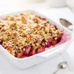 Golden brown rhubarb crisp with oat crumble and vanilla ice cream.