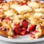 Easy strawberry dump cake recipe with golden crumb topping and melting vanilla ice cream.