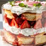 Layered strawberry shortcake trifle with juicy berries and fluffy cream in glass bowl