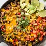 Turkey taco skillet with seasoned meat beans corn and melted cheese over rice