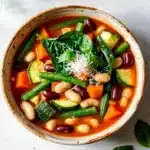 Hearty veggie loaded minestrone soup with beans and pasta in creamy broth