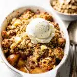 Warm apple cinnamon crumble with creamy sauce and crispy oat topping.