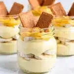 Layered banana pudding parfait in a jar with vanilla wafers and whipped cream.
