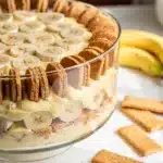 Layered banana pudding dessert with vanilla wafers in a glass trifle bowl