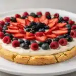Colorful berry fruit pizza on a sweet sugar cookie crust with cream cheese frosting.