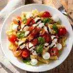 Colorful Caprese pasta salad with tomatoes mozzarella and basil in balsamic vinaigrette