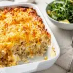 Creamy cheesy crockpot hashbrown casserole recipe with potatoes and melted cheese.