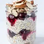 Cherry almond overnight oats in a mason jar with natural morning light