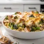 Creamy chicken broccoli alfredo bake with golden cheese topping in ceramic dish