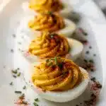 Classic deviled eggs with creamy filling and paprika on rustic wood