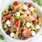 Colorful Italian pasta salad with rotini, pepperoni, and homemade dressing in a bowl.
