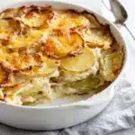Creamy scalloped potatoes recipe with golden crispy cheese topping in close up
