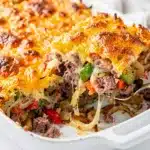 Corned beef hash breakfast casserole slice with crispy cheese and bell peppers.