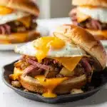 Corned beef hash breakfast sandwich with egg and cheese on brioche bun.