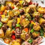 Crispy corned beef hash with creamy mustard sauce in a rustic skillet.