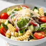 Creamy Caesar pasta salad with Greek yogurt and fresh vegetables in a bowl