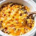 Creamy crockpot hashbrown casserole with melted cheese and crispy golden potato edges.