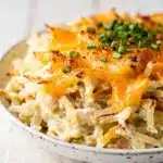 Creamy crockpot hashbrown potatoes casserole with melted cheese and chives.