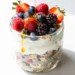 Creamy high protein overnight oats with Greek yogurt topped with fresh berries and honey