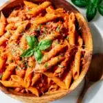 Creamy tomato basil pasta with penne in a glossy sauce and fresh basil