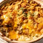 Creamy crockpot hashbrown casserole with caramelized onions and crispy cornflake topping.