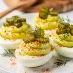 Creamy dill pickle deviled eggs with fresh dill and paprika garnish.