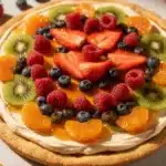 Homemade sugar cookie fruit pizza with cream cheese frosting and fresh berries