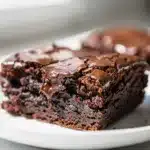 Fudgy brownies with a crackly top sliced to reveal a dark chocolate interior.