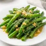 Garlic butter green beans recipe with glossy sauce and minced garlic pieces