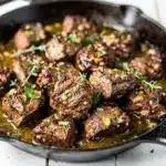 Skillet garlic butter steak bites seared golden brown with fresh herbs.