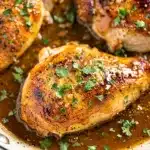Honey garlic chicken breast skillet with sticky glaze and fresh parsley garnish