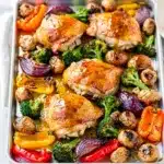 Sheet pan honey mustard chicken with roasted vegetables on a baking sheet