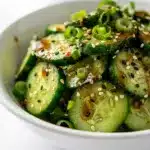 Crisp Korean cucumber salad with glossy sesame dressing in close up view