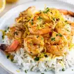 Lemon garlic shrimp and rice in a rustic ceramic bowl with parsley.