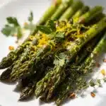 Lemon herb roasted asparagus with garlic and thyme on a white platter