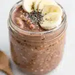 Creamy mocha overnight oats with chia seeds, banana, and coffee bean topping.