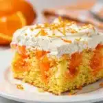 Orange creamsicle jello poke cake with fluffy vanilla cream frosting