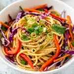Colorful sesame noodle pasta salad with creamy tahini sauce and fresh vegetables.