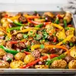 Sheet pan sausage and potatoes recipe with roasted vegetables on baking sheet
