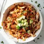 Slow cooker salsa chicken recipe with shredded chicken in vibrant red salsa