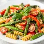 Colorful spring vegetable pasta primavera in creamy Parmesan sauce with fusilli.