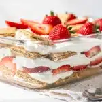 Strawberry icebox cake slice with creamy layers and fresh strawberry garnish.