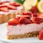 A slice of strawberry lemonade pie with creamy filling on a white plate.