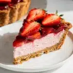 A slice of Strawberry Pretzel Pie with creamy filling and glossy berry topping.