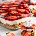 Layered strawberry pretzel salad dessert with creamy filling and vibrant red Jell-O.