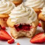 Strawberry shortcake cupcakes with vanilla frosting and fresh berry garnish