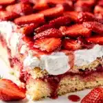 Strawberry shortcake sheet cake with whipped cream and fresh juicy berries.