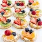 Colorful sugar cookie fruit pizza bites with fresh strawberries, blueberries, and kiwi.